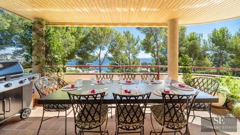 Bright living room with large windows offering panoramic sea views. Modern and elegant design with touches of wood and natural stone.