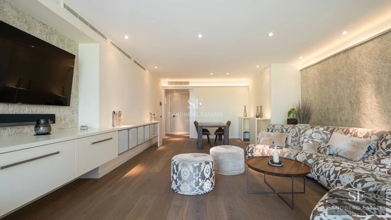 Bright living room with balcony and sea view. Modern design, light wood floors, and elegant furniture.