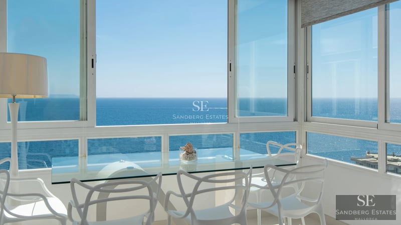 Spacious living room with panoramic windows. Light wood floors, modern fireplace, and designer furniture. Views of greenery.