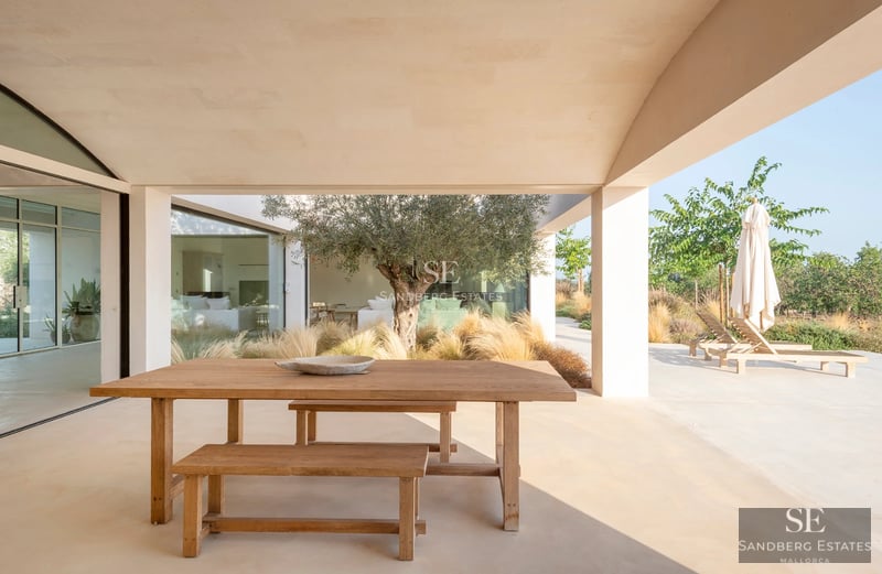 Vista de una lujosa villa con piscina, jardín y grandes ventanales. Arquitectura moderna y elegante con acabados de alta calidad.