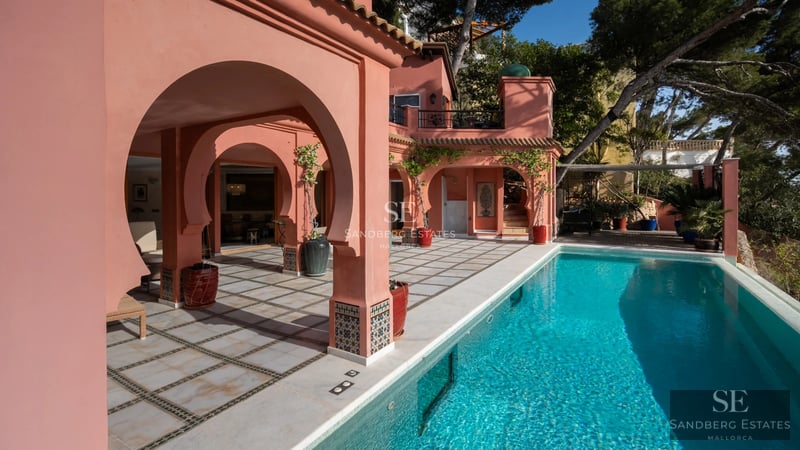 Expansive pool with sundeck, lounge chairs, and panoramic views. Modern, sleek design with lush greenery.