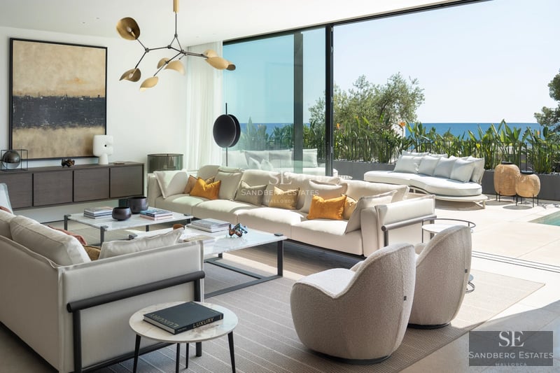 Vista exterior de una moderna vivienda con piscina, jardín exuberante y amplias zonas de estar al aire libre. Diseño contemporáneo.