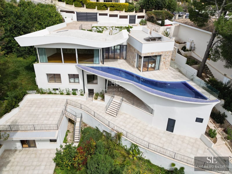 Spacious balcony with sea view. Modern design, glass railing, wood flooring. Minimalist outdoor furniture.