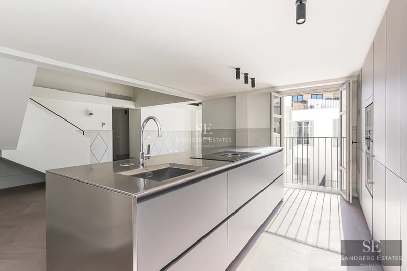 Spacious living room with picture windows, sea views and modern furniture. Light wood floors and neutral color palette.