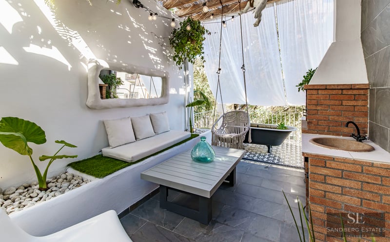 Chic Mediterranean Terrace with Outdoor Spa Sun-drenched white terrace with built-in sofa, macrame swing, brick outdoor sink, and a black clawfoot bathtub.