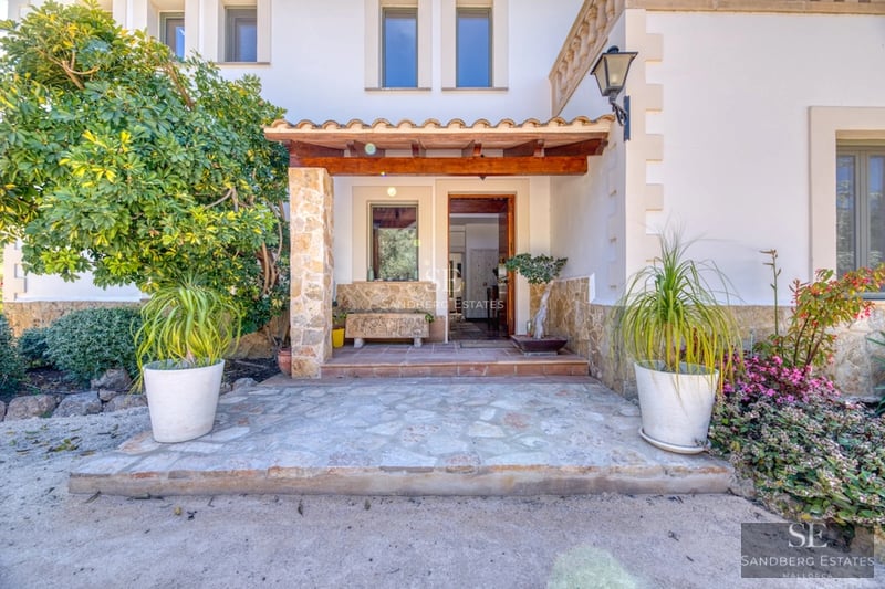 View of a modern villa with infinity pool, sun loungers, and lush vegetation. Sleek architectural design with large windows.