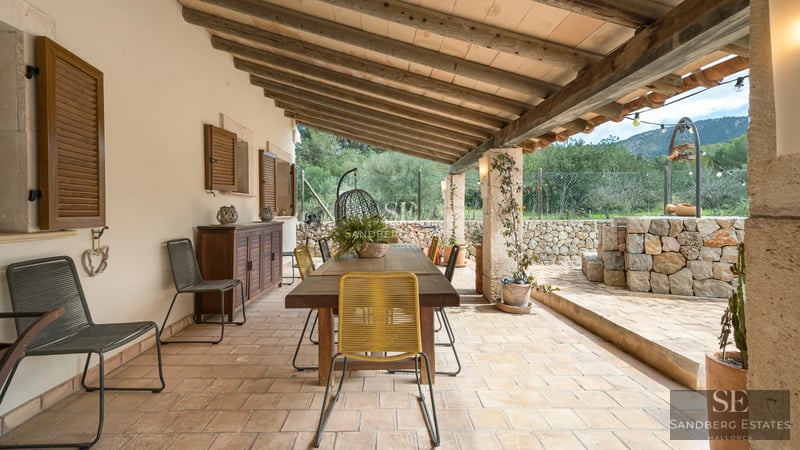 Spacious living room with fireplace, large windows, wood floors, and light walls. Modern sofa and minimalist decor.