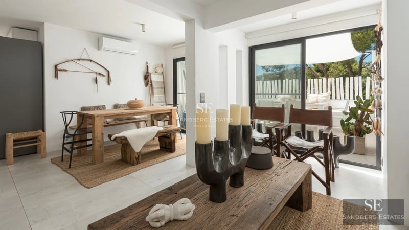 Vista exterior de una lujosa villa con piscina, jardín exuberante y arquitectura moderna. Iluminación cálida y amplios ventanales.