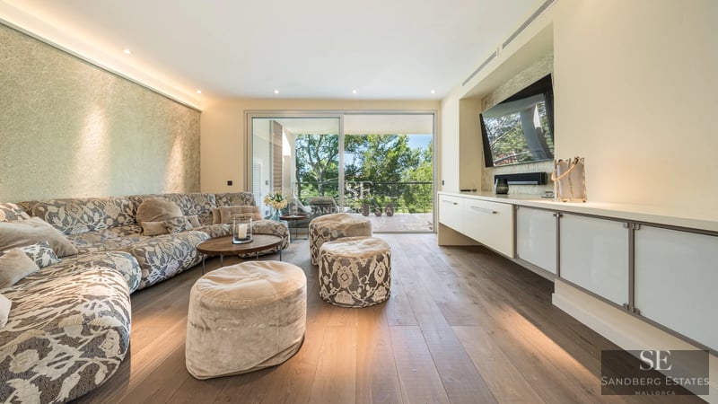 View of a luxurious pool with garden and an elegant modern home. Minimalist design features large windows and lush greenery.