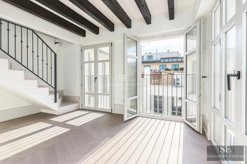 View of a luxury pool with sun loungers and umbrellas in a modern property with minimalist architecture and lush gardens.