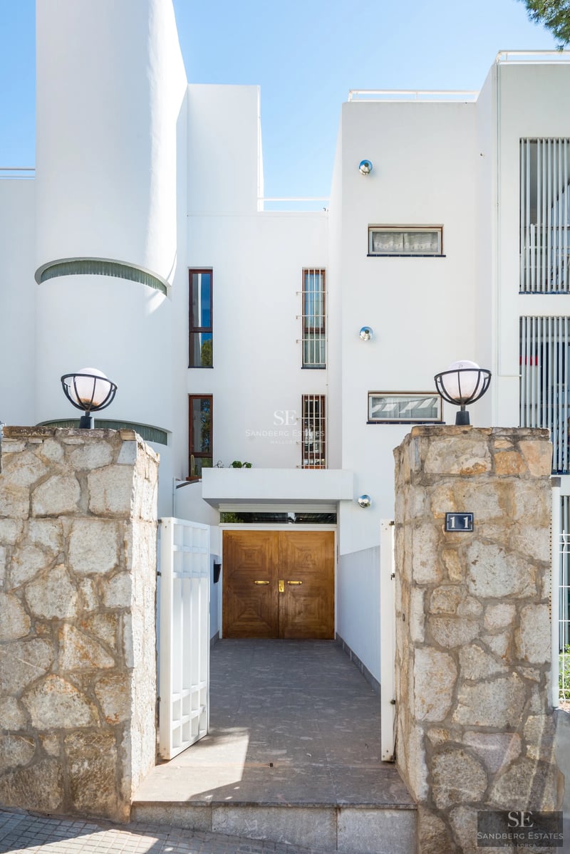 Exterior of a modern villa featuring a swimming pool, manicured garden, and expansive windows. Minimalist architectural design.