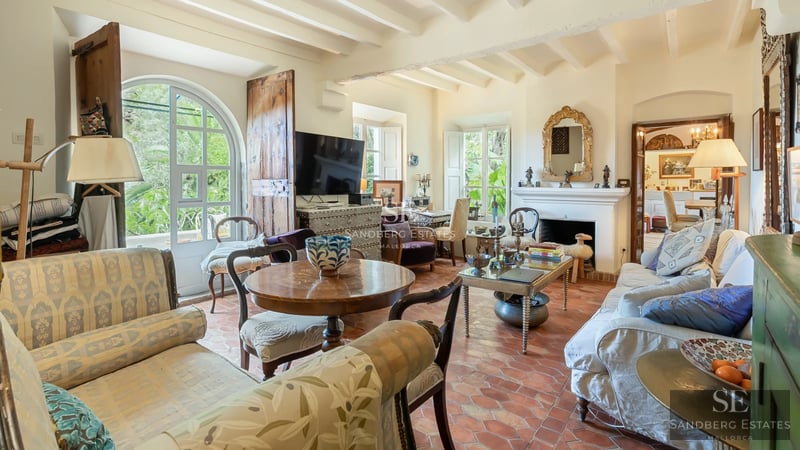 Panoramic view of infinity pool, surrounded by greenery. Modern design with warm lighting and unobstructed views.