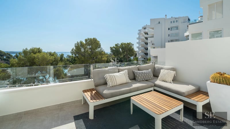 View of a luxurious villa with infinity pool, surrounded by greenery and spacious terraces. Modern and bright architecture.