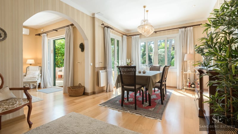 Exterior view of a modern villa with pool, lush garden, and spacious terraces. Minimalist architecture with large windows.