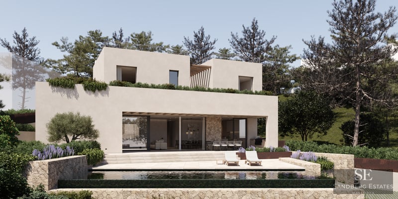A modern two-story beige villa with an infinity pool, stone walls, and sun loungers under a clear sky.