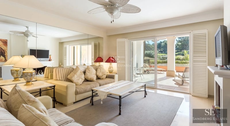 Spacious balcony with sea view, glass railing, wooden floor, outdoor seating area. Modern and elegant design.