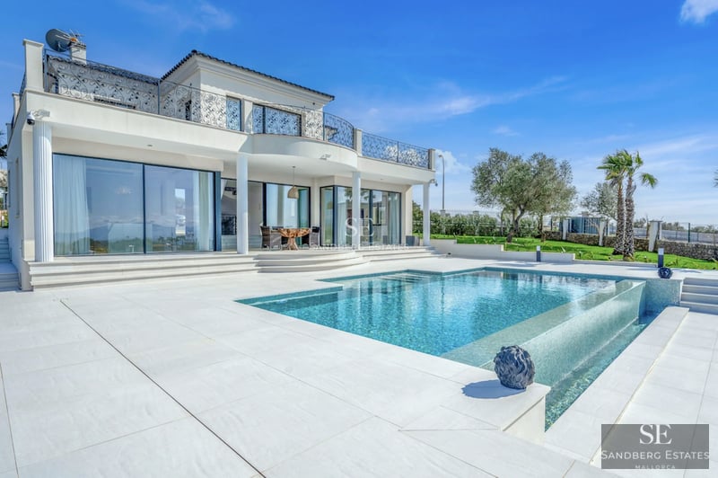 Spacious living room with pool view. Modern design, natural light, neutral colors. Light wood floors and elegant furniture.