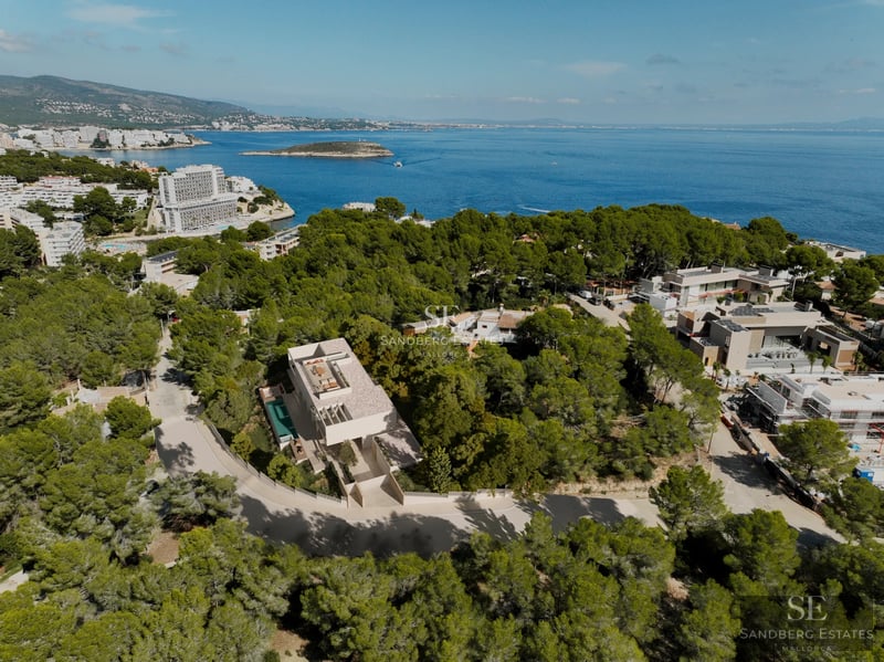 Spacious terrace with infinity pool, sun loungers, and panoramic sea views. Modern design featuring ambient lighting and lush vegetation.