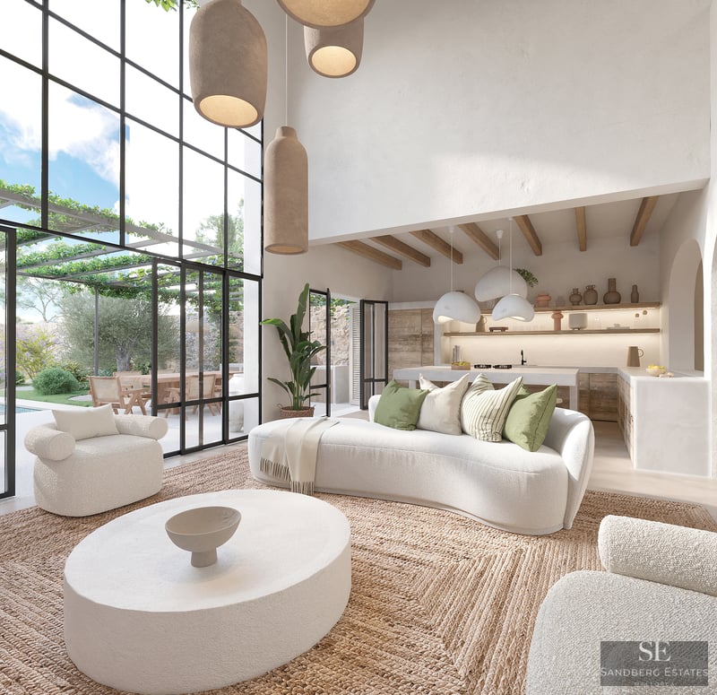 Amplio salón blanco con sofás curvos, alfombra de yute y grandes ventanales que muestran una terraza jardín.