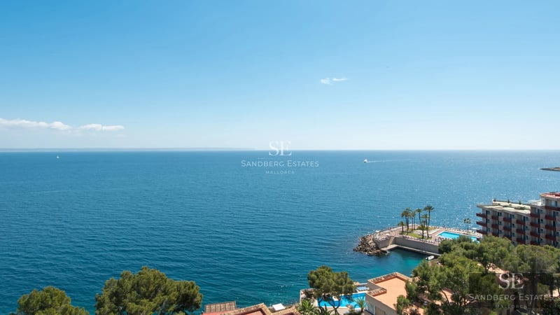 View of a modern house with infinity pool. Minimalist design, large windows, natural light, surrounded by lush vegetation.
