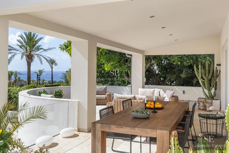 Expansive terrace with infinity pool and panoramic views. Modern design featuring wood flooring, sun loungers, and minimalist architecture.