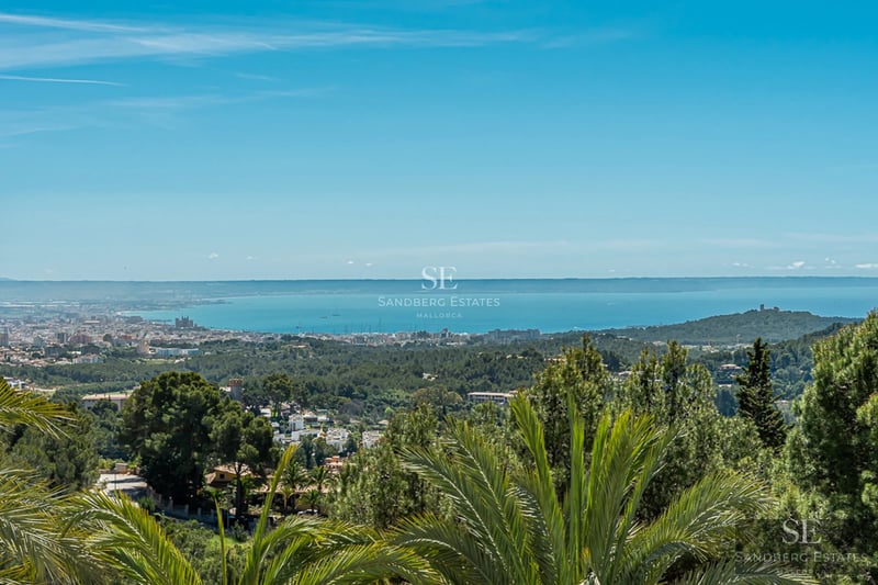 Bright living room with large windows, designer furniture, and panoramic sea views. Beige sofa, elegant coffee table, and modern decor.