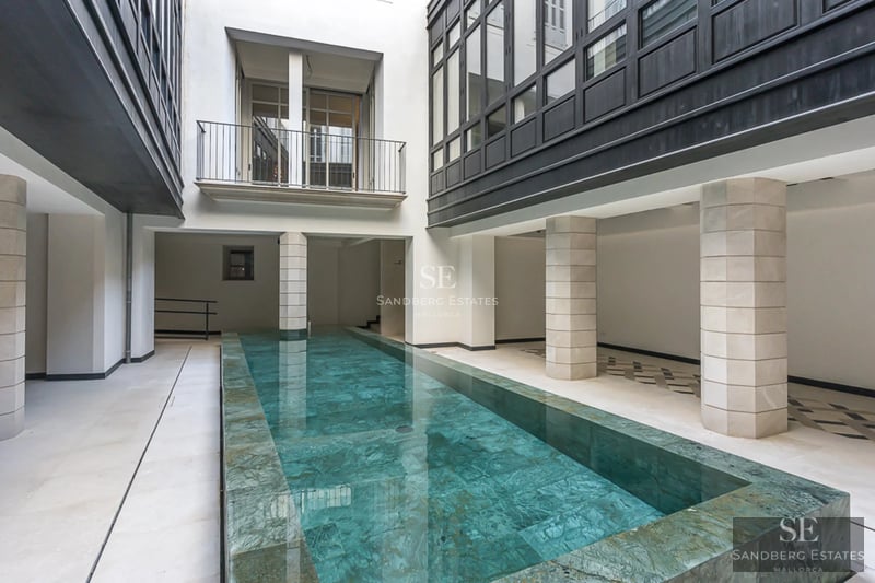 Spacious balcony with sea view, modern furniture, glass railing, wooden floor. Minimalist and elegant design.