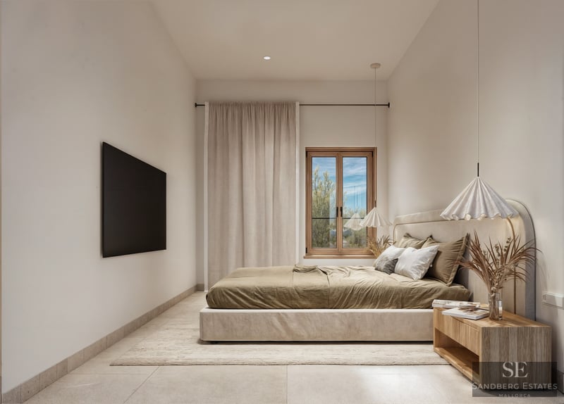 A minimalist bedroom with an upholstered bed, wooden side table, pendant lights, and natural light from a window.
