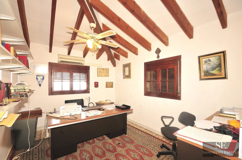 Spacious living room with window walls, beige sofas, fireplace and sea view. Elegant interior design with natural lighting.