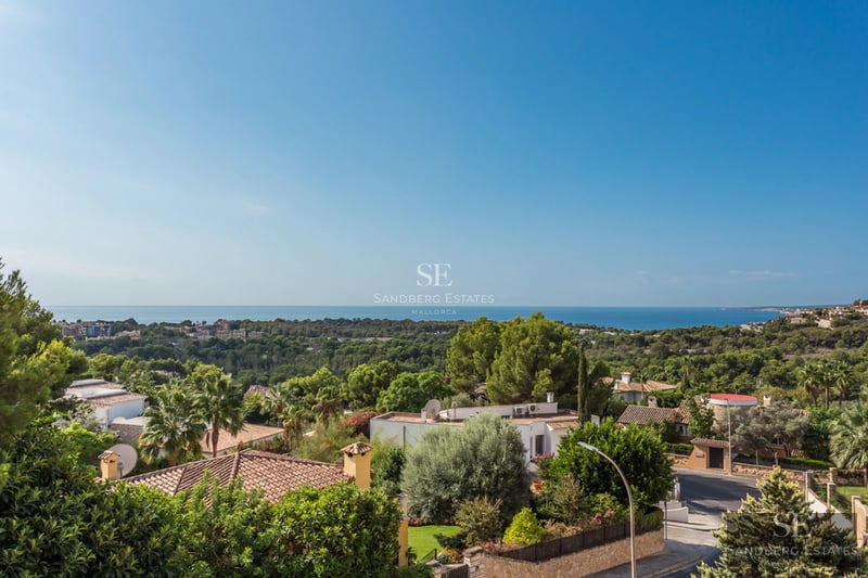 Spacious living room with floor-to-ceiling windows overlooking the sea, modern furniture, natural light, and neutral color palette. Sleek, minimalist design.