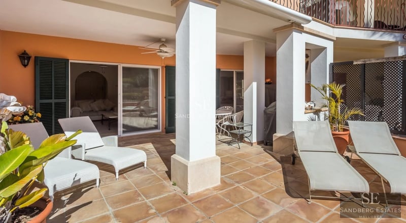 Exterior view of modern villa with swimming pool, minimalist architecture, large windows, manicured garden and clear sky.