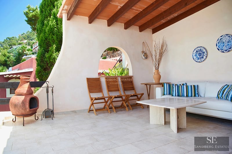 View of a luxury apartment with pool, furnished terrace and modern design. Bright interior with large windows.