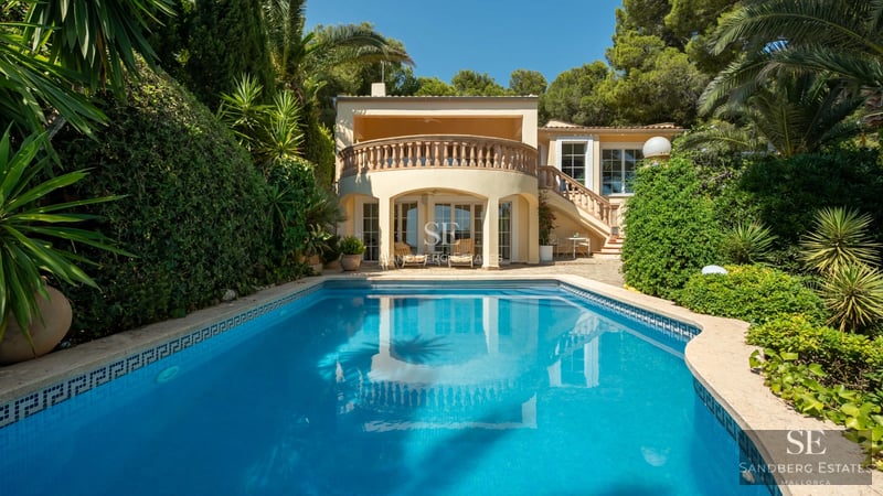 Spacious living room with floor-to-ceiling windows, designer sofas, wooden coffee table, textured rug and panoramic sea view.