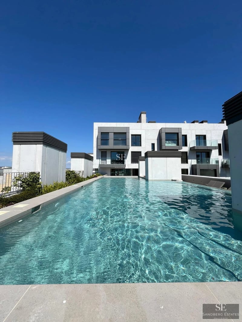 View of luxurious villa with infinity pool, lush garden, and modern architecture. Warm lighting and serene atmosphere.