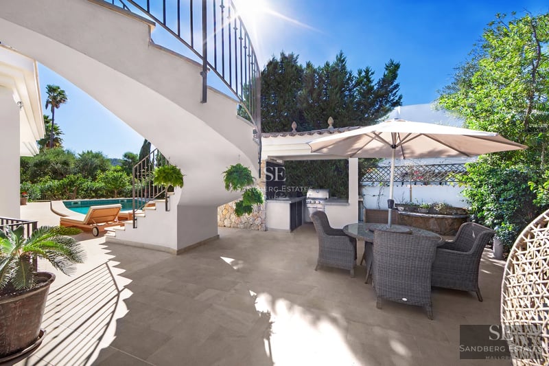 View of the modern facade of a villa with a pool, garden, and large windows. Minimalist and elegant design.