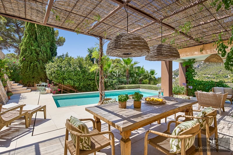 Expansive terrace with infinity pool and panoramic views. Modern, minimalist design with stylish outdoor furniture and lush vegetation.