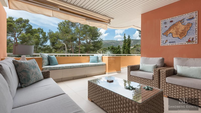 Spacious living room featuring modern fireplace, natural light, beige sofas, and wood flooring. Elegant, welcoming design.