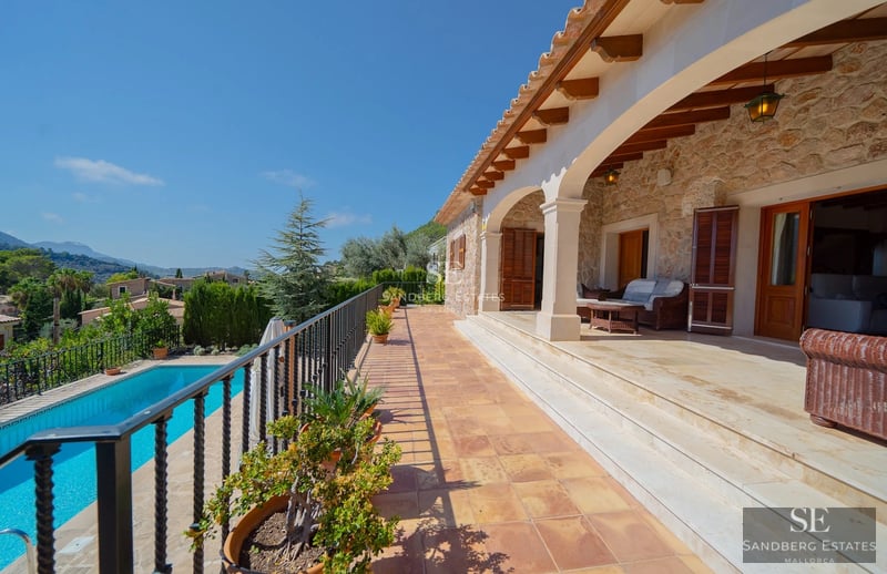 Exterior view of modern villa featuring an infinity pool, lush garden, and expansive terraces. Contemporary architecture, ideal for relaxation.