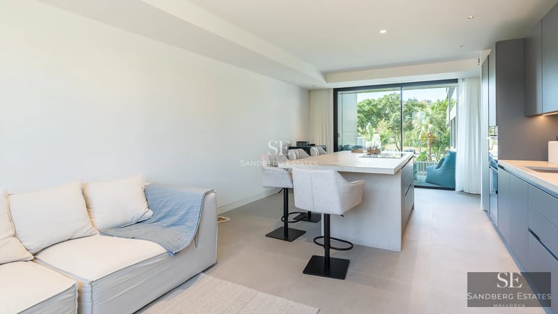 View of pool and modern house with large windows, lush greenery, and partially cloudy sky. Contemporary architecture.