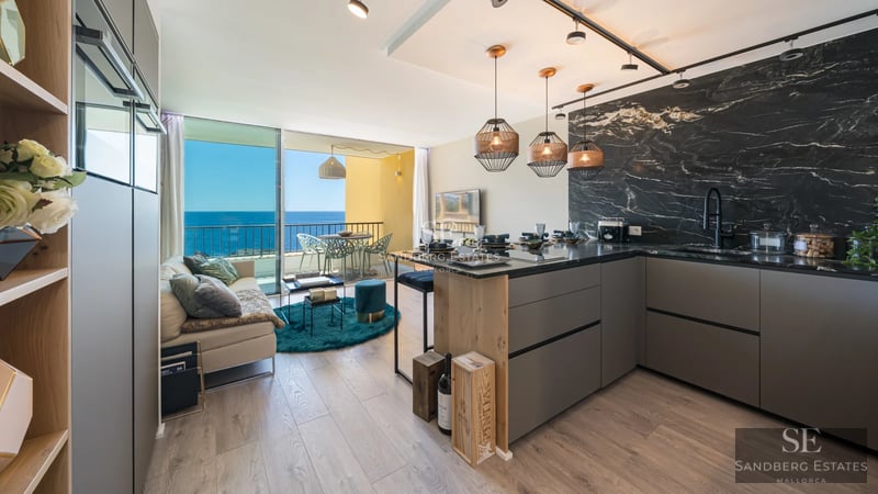 Exterior view of a modern villa featuring an infinity pool, lush garden, and panoramic sea views. Minimalist architecture.