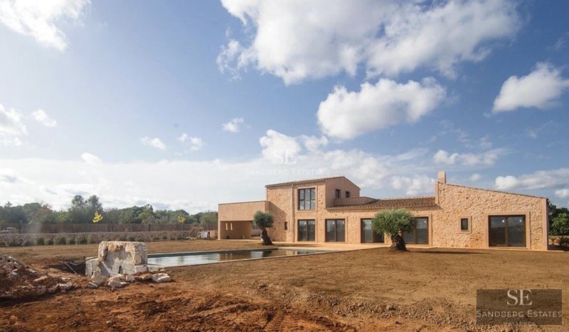 Exterior view of a modern villa with pool, surrounded by greenery. Minimalist architecture, large windows, and luxury finishes.