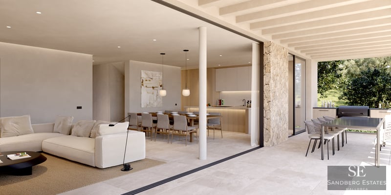 Spacious indoor living room with white sofa flowing into an outdoor terrace with dining and kitchen areas.