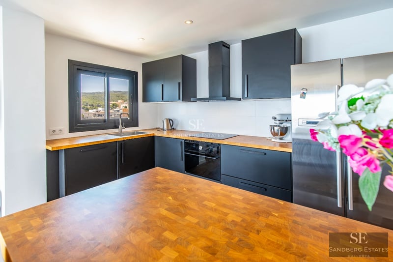 Spacious balcony with panoramic sea views. Modern outdoor furniture, wooden floor, glass railing.