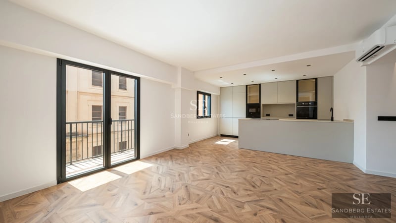 Geräumiges Wohnzimmer mit großen Fenstern und Meerblick. Modernes Sofa, Couchtisch und Design-Details. Warme Beleuchtung und entspannende Atmosphäre.