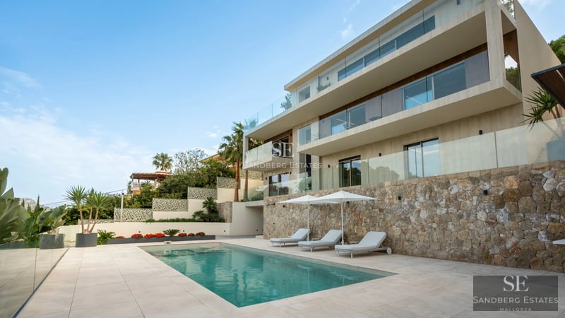 Exterior view of a modern house with a pool, manicured gardens, and large windows reflecting natural light. Minimalist and elegant design.