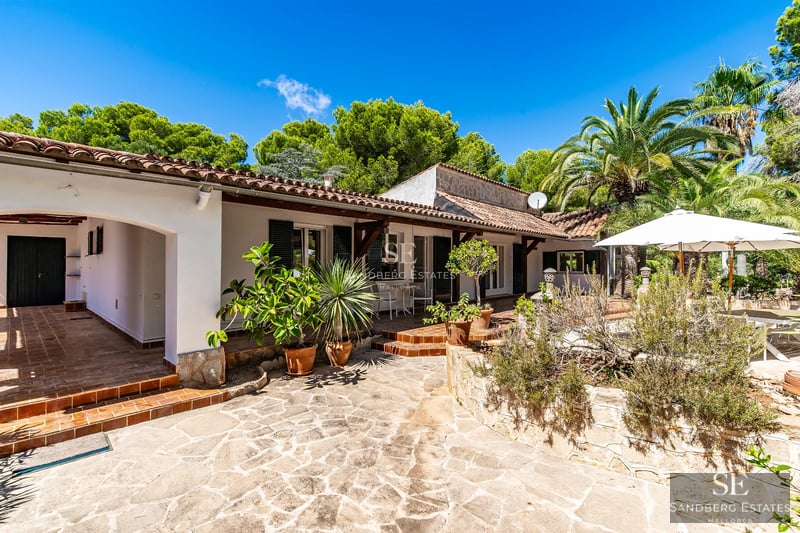 Modern exterior with infinity pool, minimalist garden, white facade and large windows. Warm ambient lighting.