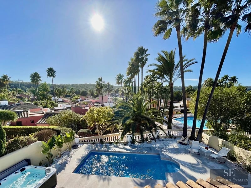 Exterior of a modern villa featuring an infinity pool, landscaped garden, and spacious terraces. Contemporary architecture with large windows.