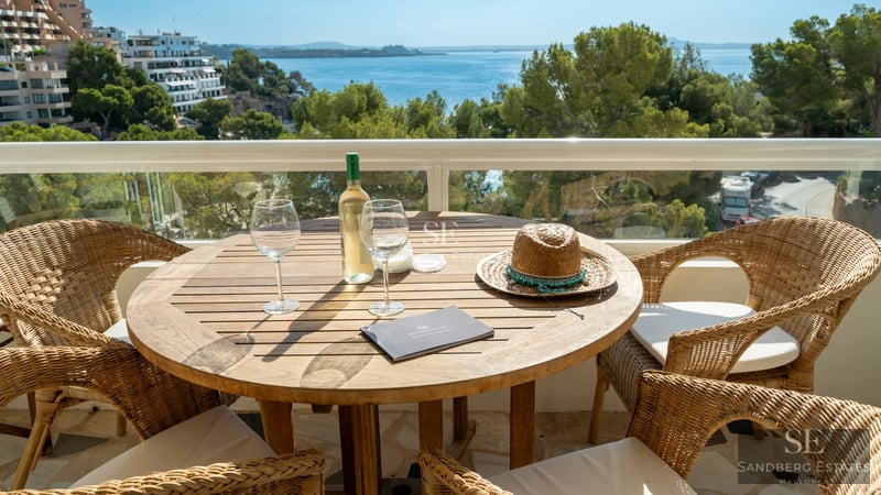 Spacious living room with floor-to-ceiling windows, modern fireplace, and access to a terrace with a pool. Minimalist design with natural light.