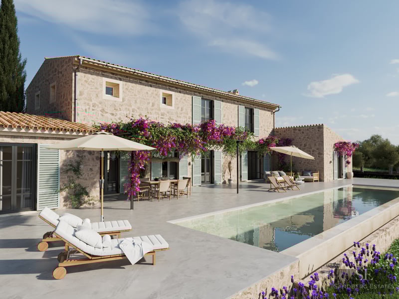 Large swimming pool next to a traditional stone villa with purple bougainvillea flowers and white sun loungers.