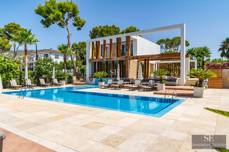 Image of a luxury villa with pool, lush gardens, and modern architecture. Natural lighting highlighting interior and exterior details.